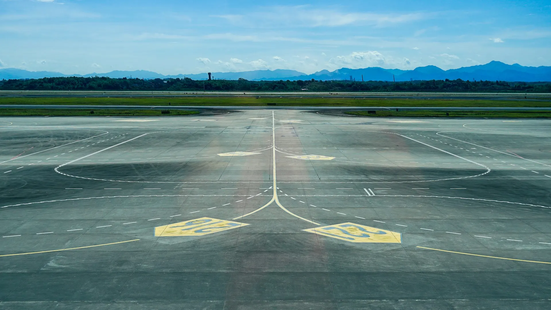 Painted taxiway centerlines and hold short markings guiding aircraft across an airport ramp